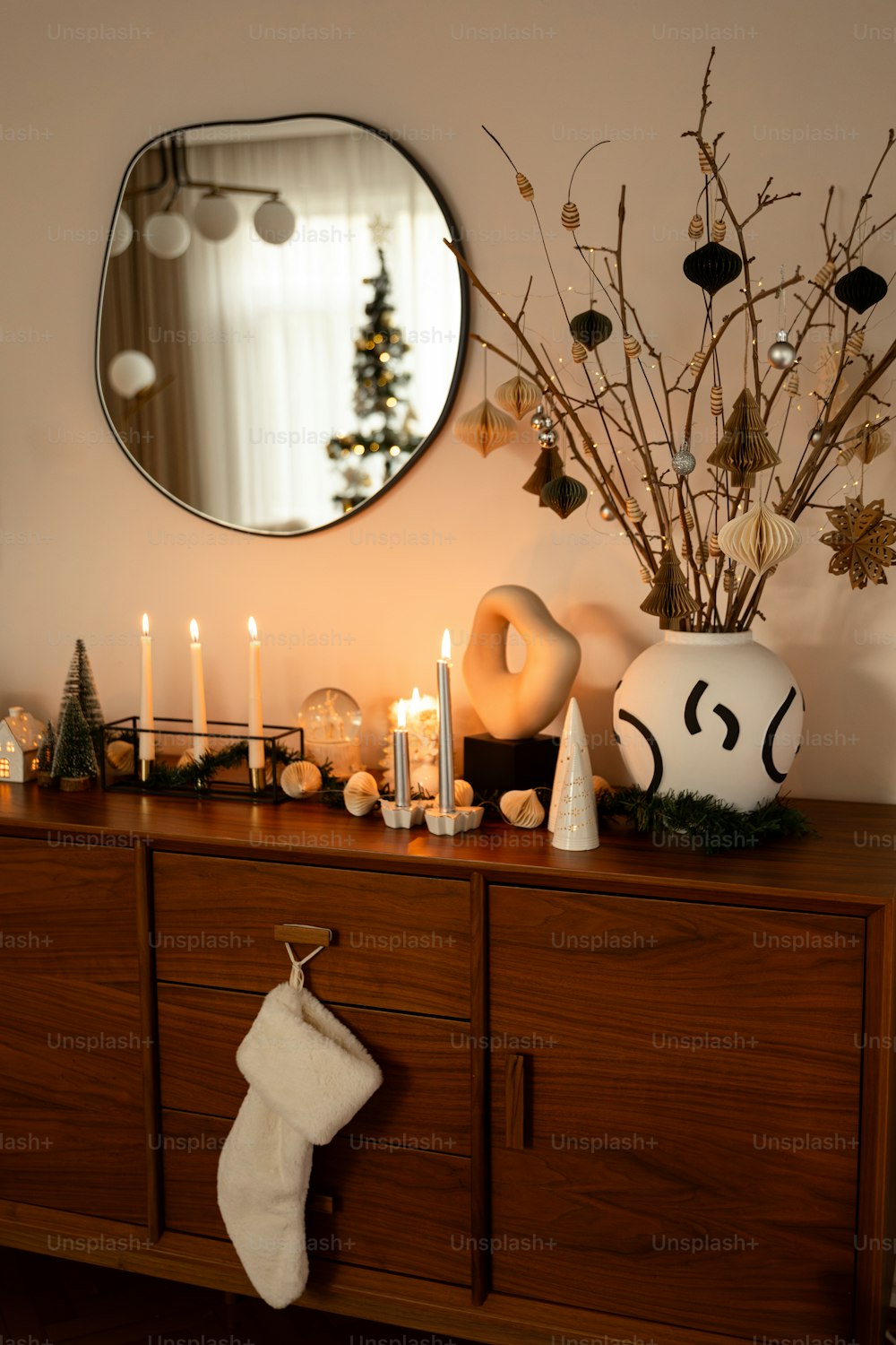 a wooden dresser topped with a mirror and a christmas stocking