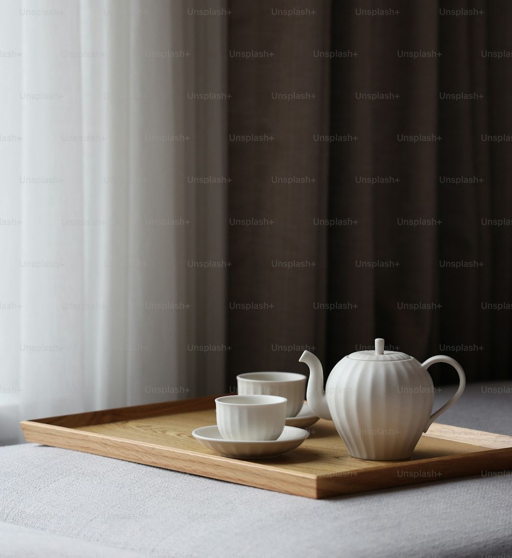 a tray with two cups and a teapot on it