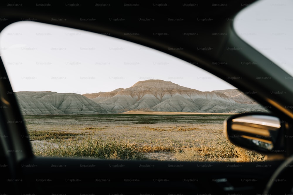 a view of a mountain range from inside a car