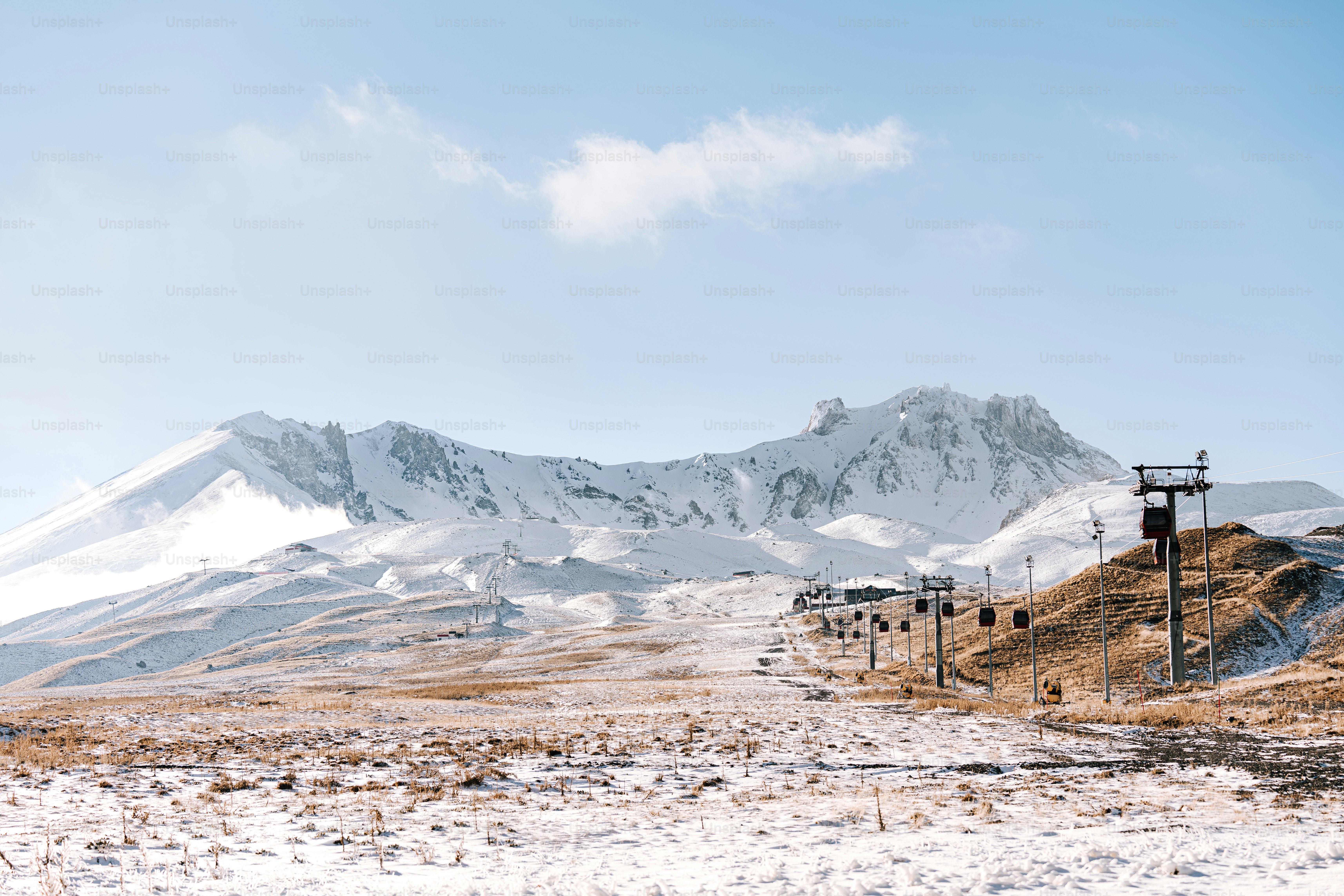 une chaîne de montagnes enneigée avec des poteaux téléphoniques au premier plan