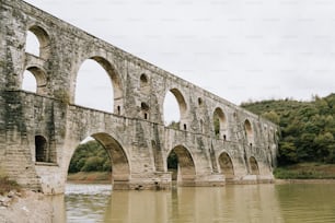 un grand pont de pierre au-dessus d’un plan d’eau