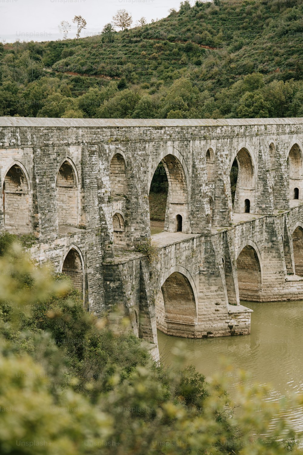 a large stone bridge spanning over a river