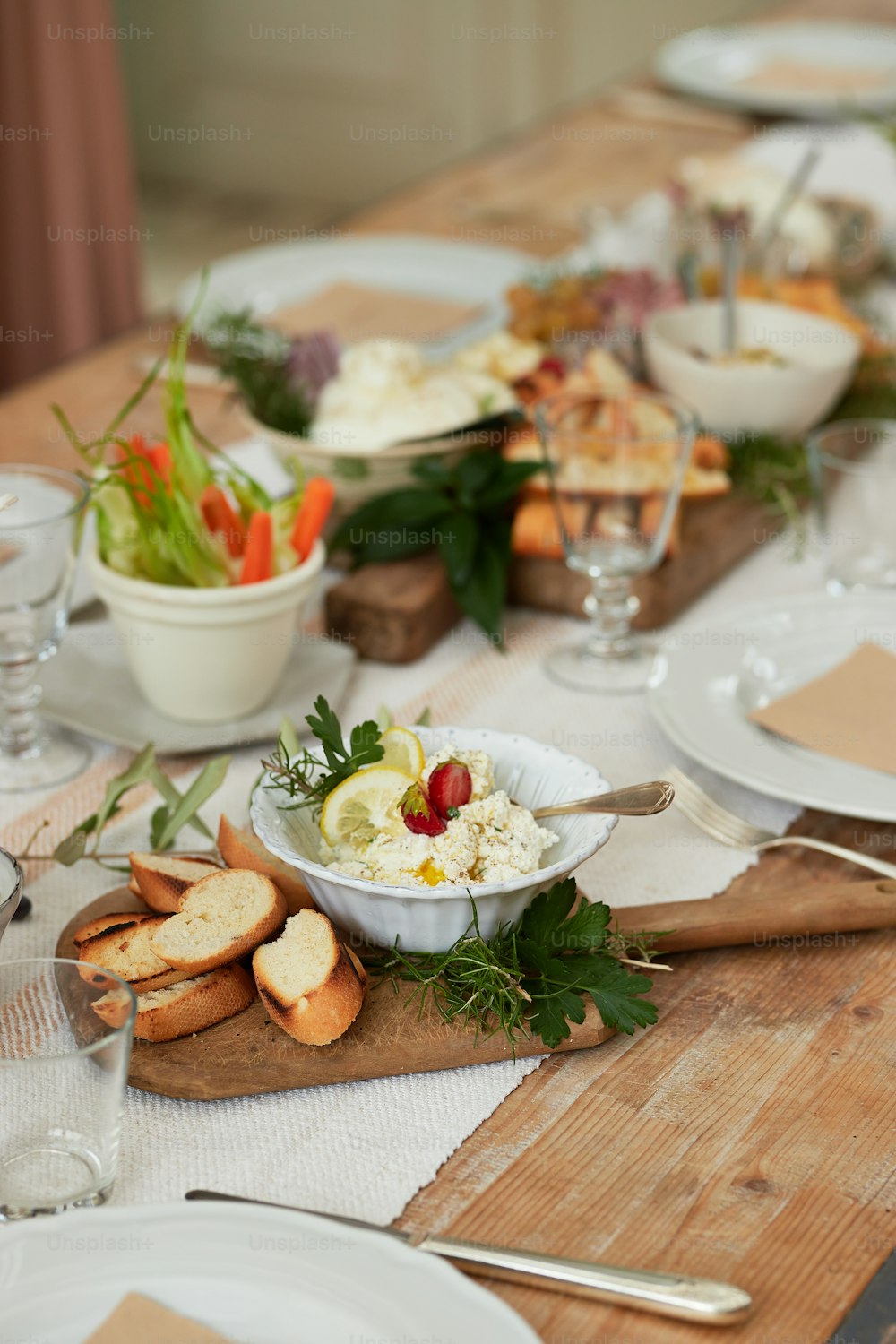 a wooden table topped with plates and bowls of food
