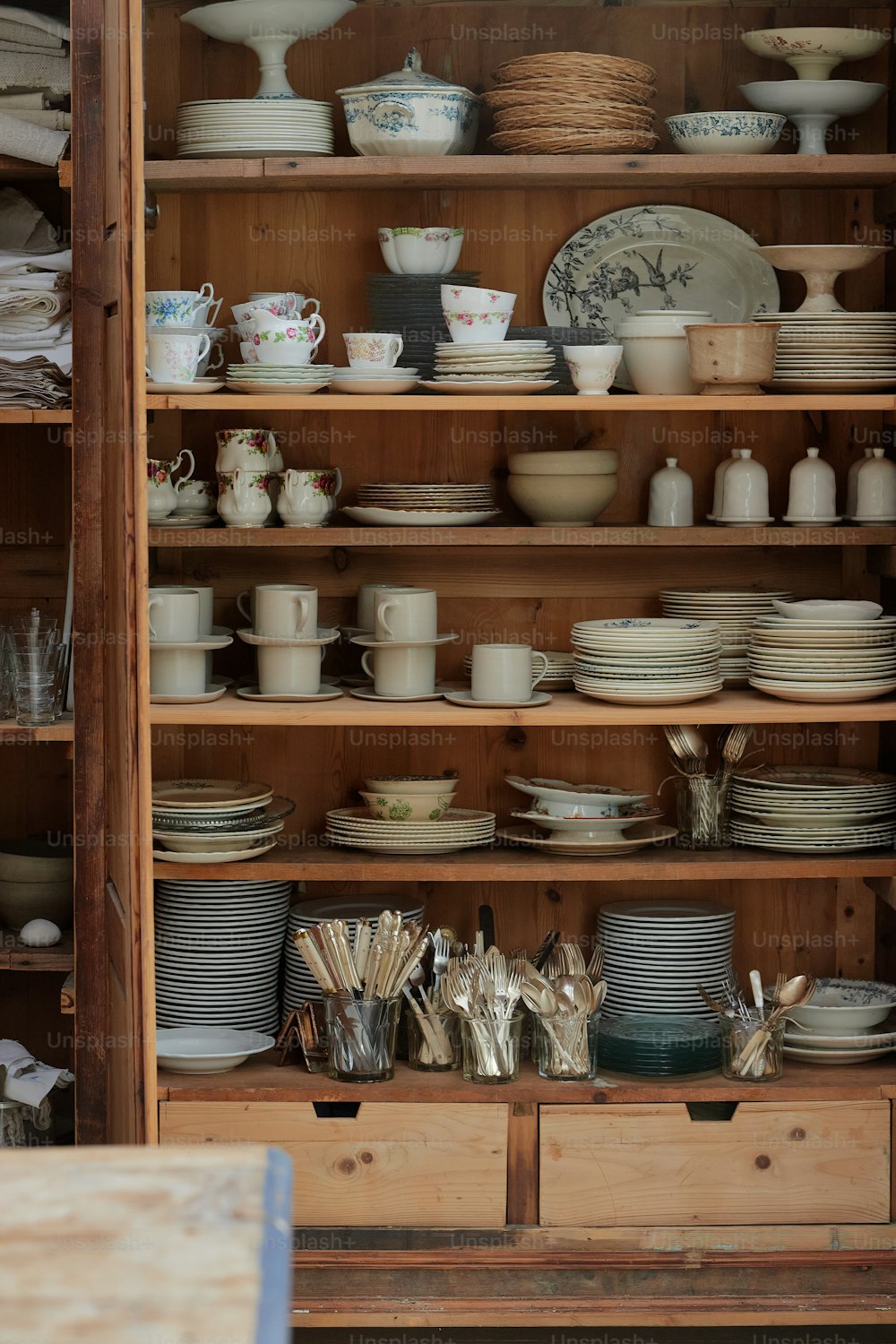 a wooden shelf filled with lots of plates and bowls