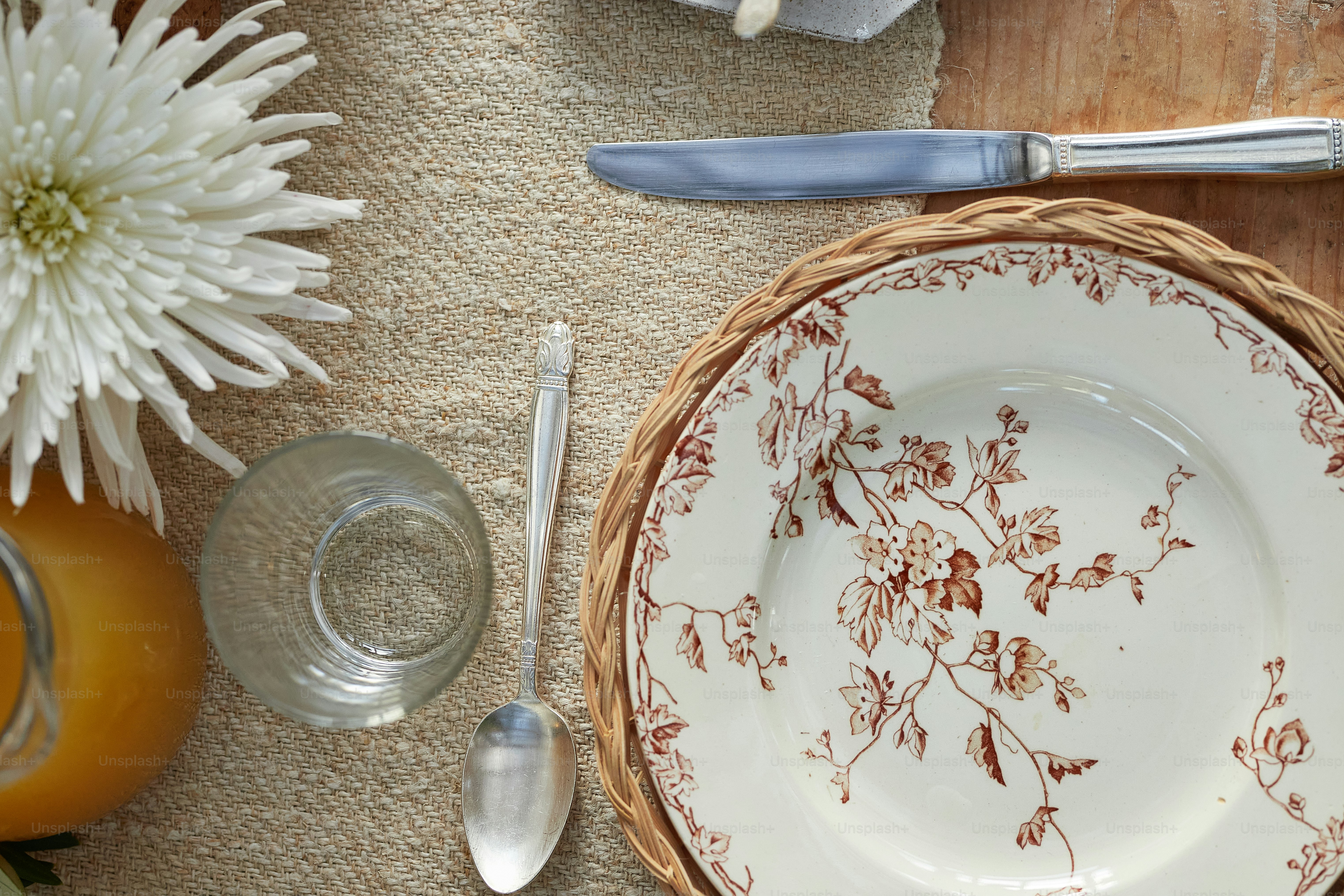 a table setting with a plate, silverware, and flowers