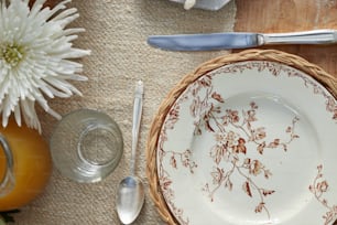 una mesa con un plato, cubiertos y flores