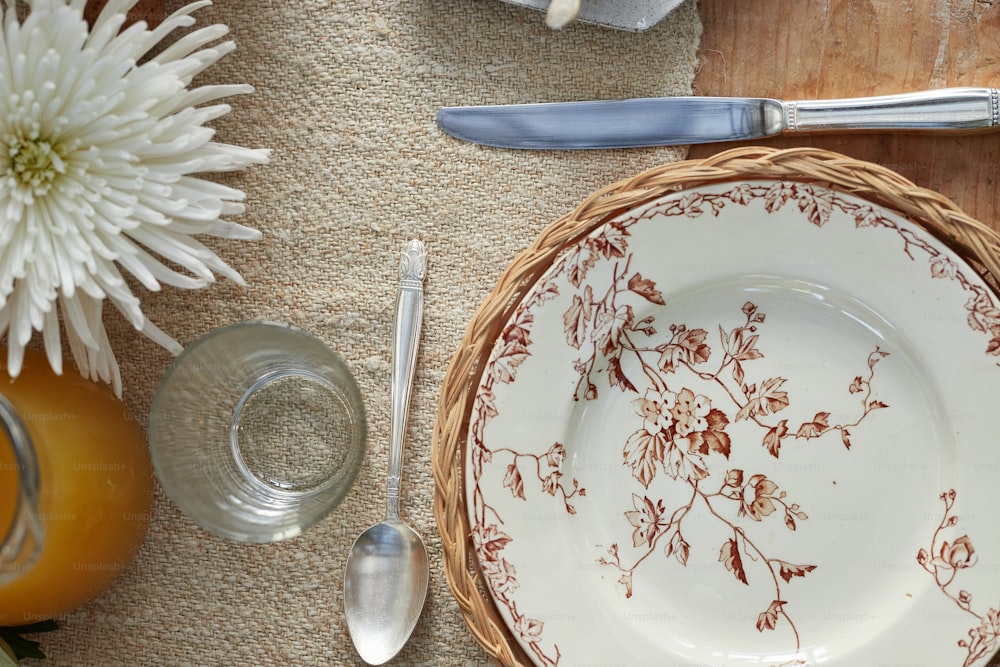 a table setting with a plate, silverware, and flowers