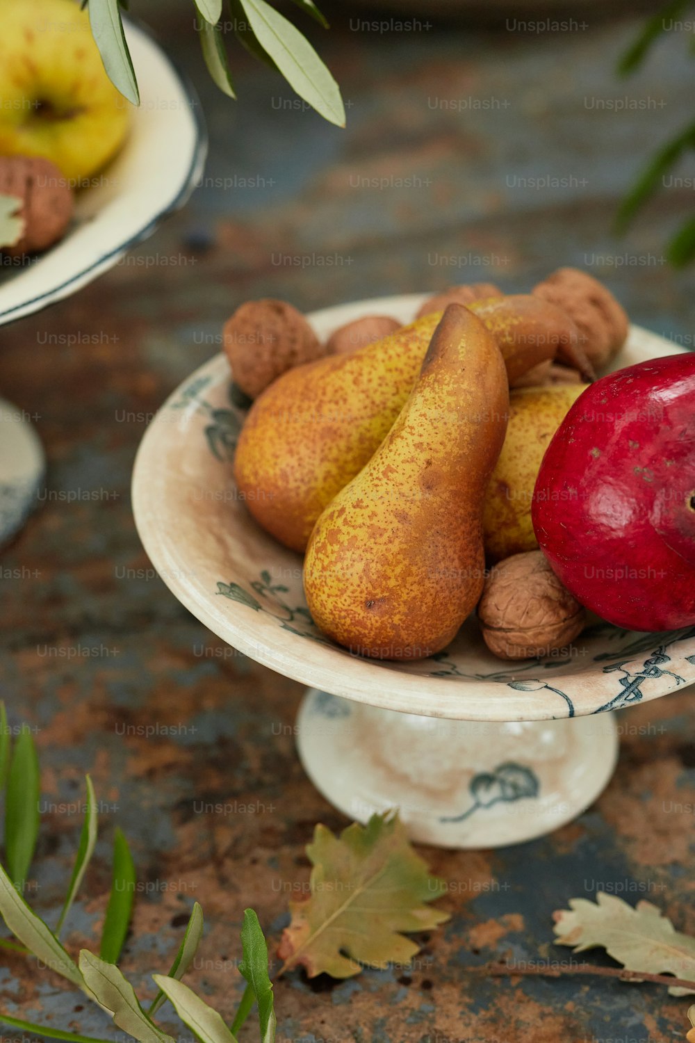 un piatto di pere, mele e noci su un tavolo