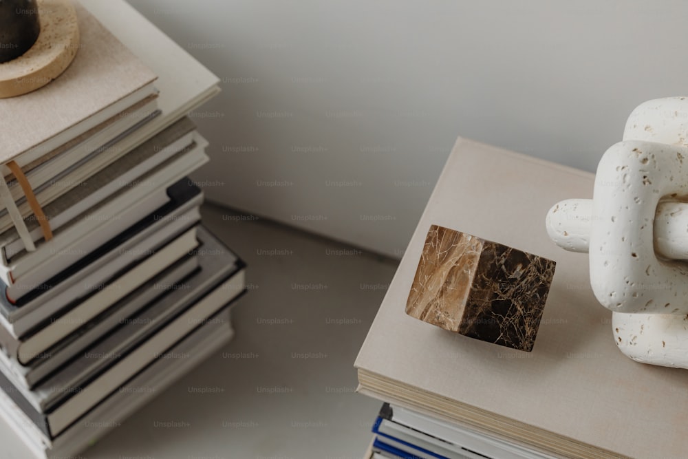 a stack of books and a sculpture on a table