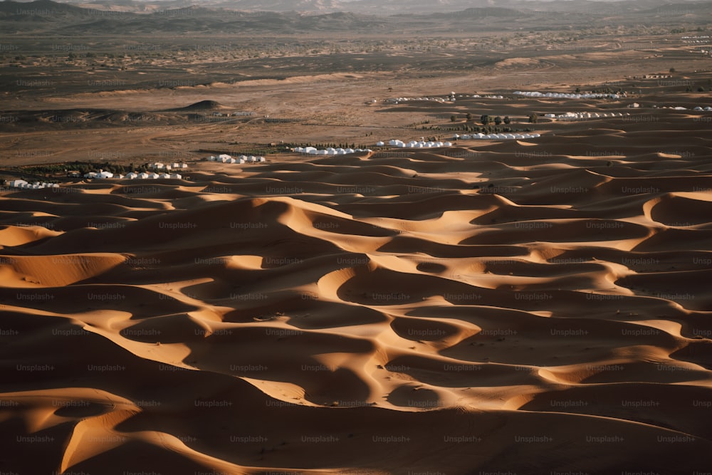 sand dunes in the desert with mountains in the background