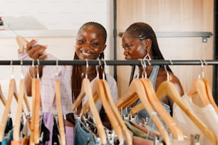 two women looking at clothes hanging on a rail