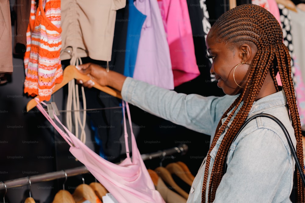 a woman looking at clothes hanging on a rack