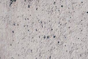 a close up of a cement surface with black dots