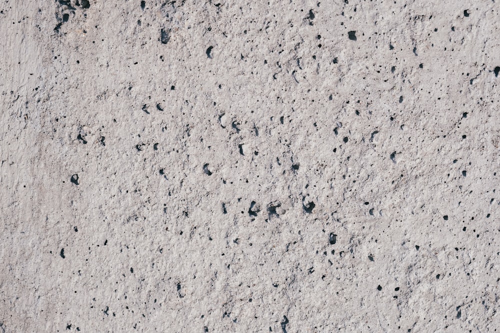 a close up of a cement surface with black dots