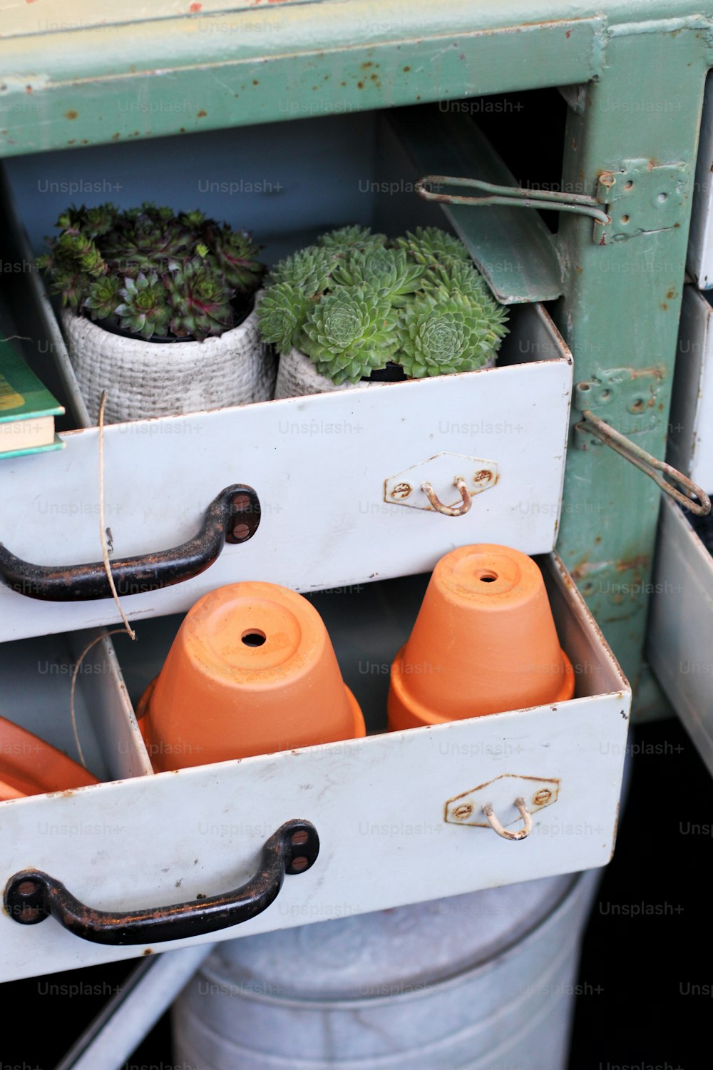 a white box filled with lots of pots and plants