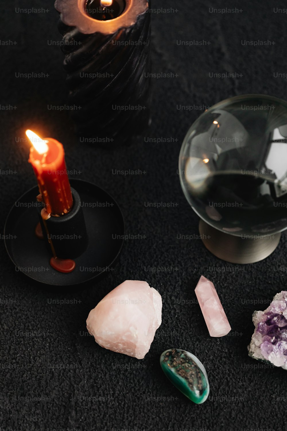 uma vela e alguns cristais sobre uma mesa
