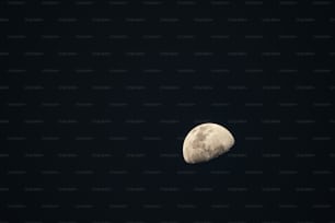 uma meia lua é vista no céu escuro