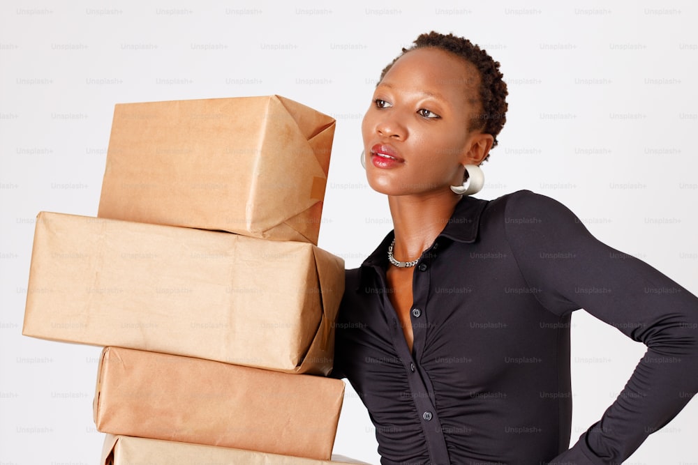 a woman is holding a stack of boxes