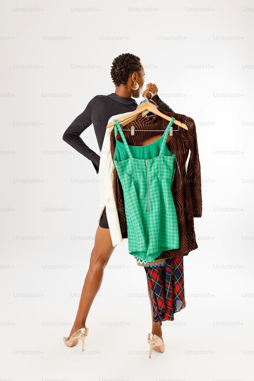 una mujer de pie junto a un perchero de ropa