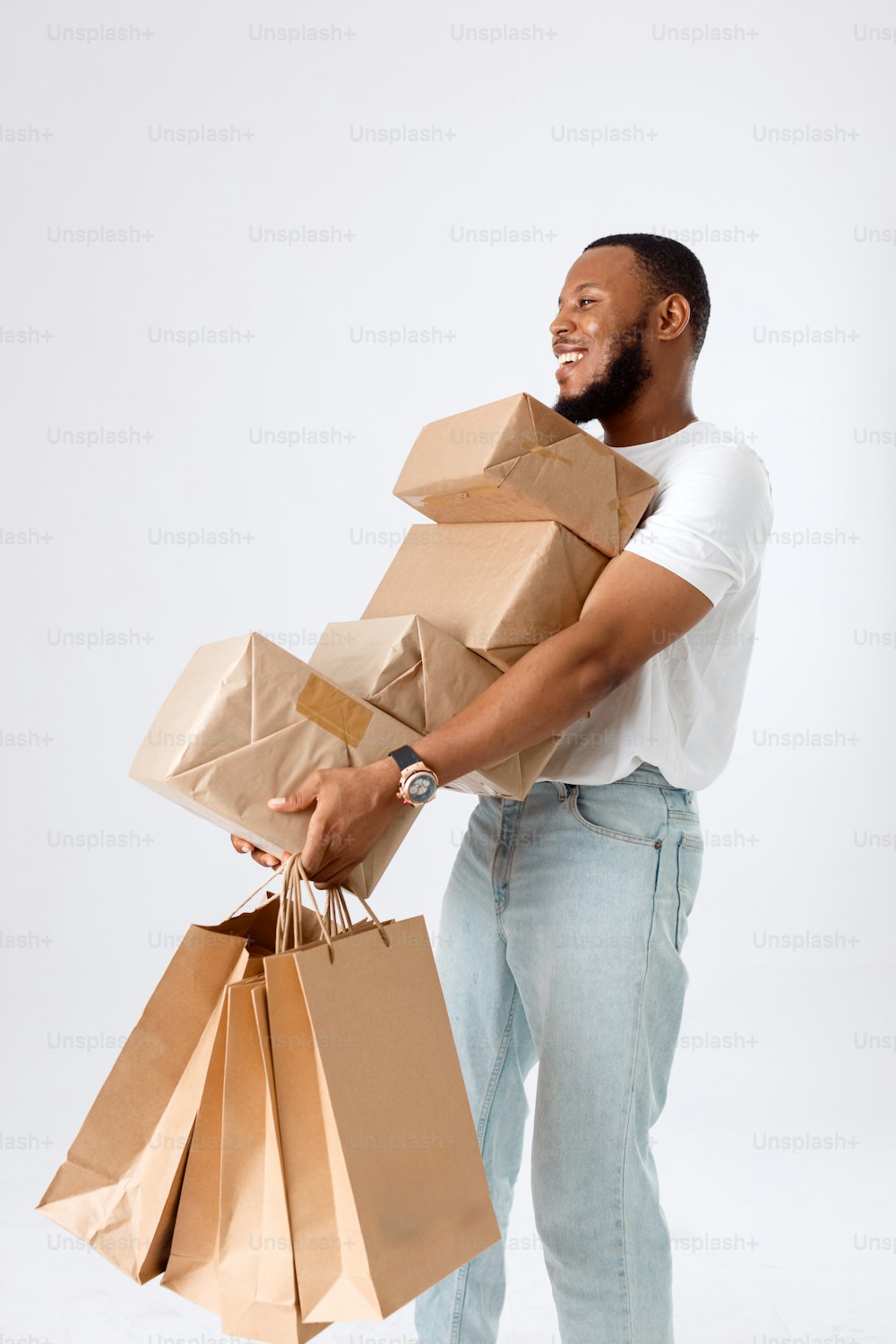 un hombre sosteniendo un montón de bolsas de papel marrón