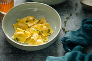 a bowl of pasta and a glass of orange juice