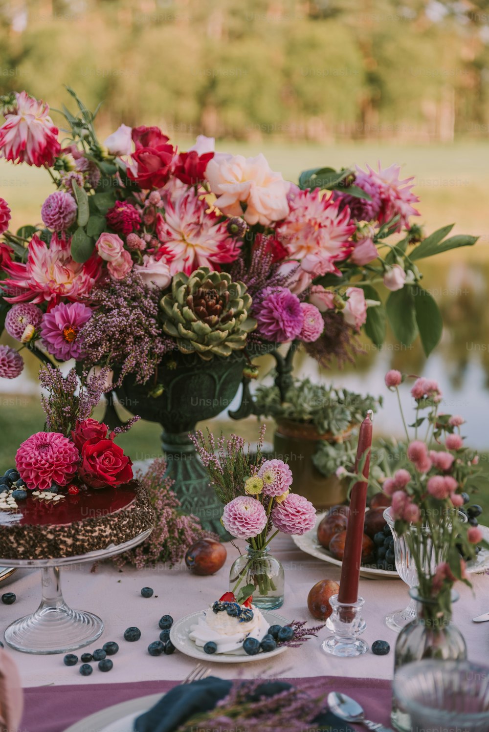 a table topped with plates and vases filled with flowers
