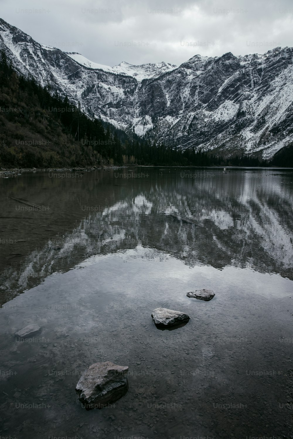 a lake surrounded by snow covered mountains