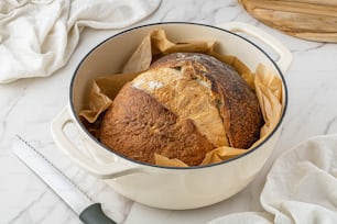 a loaf of bread sitting inside of a white pot