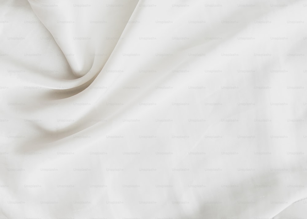 a close up of a white sheet on a bed