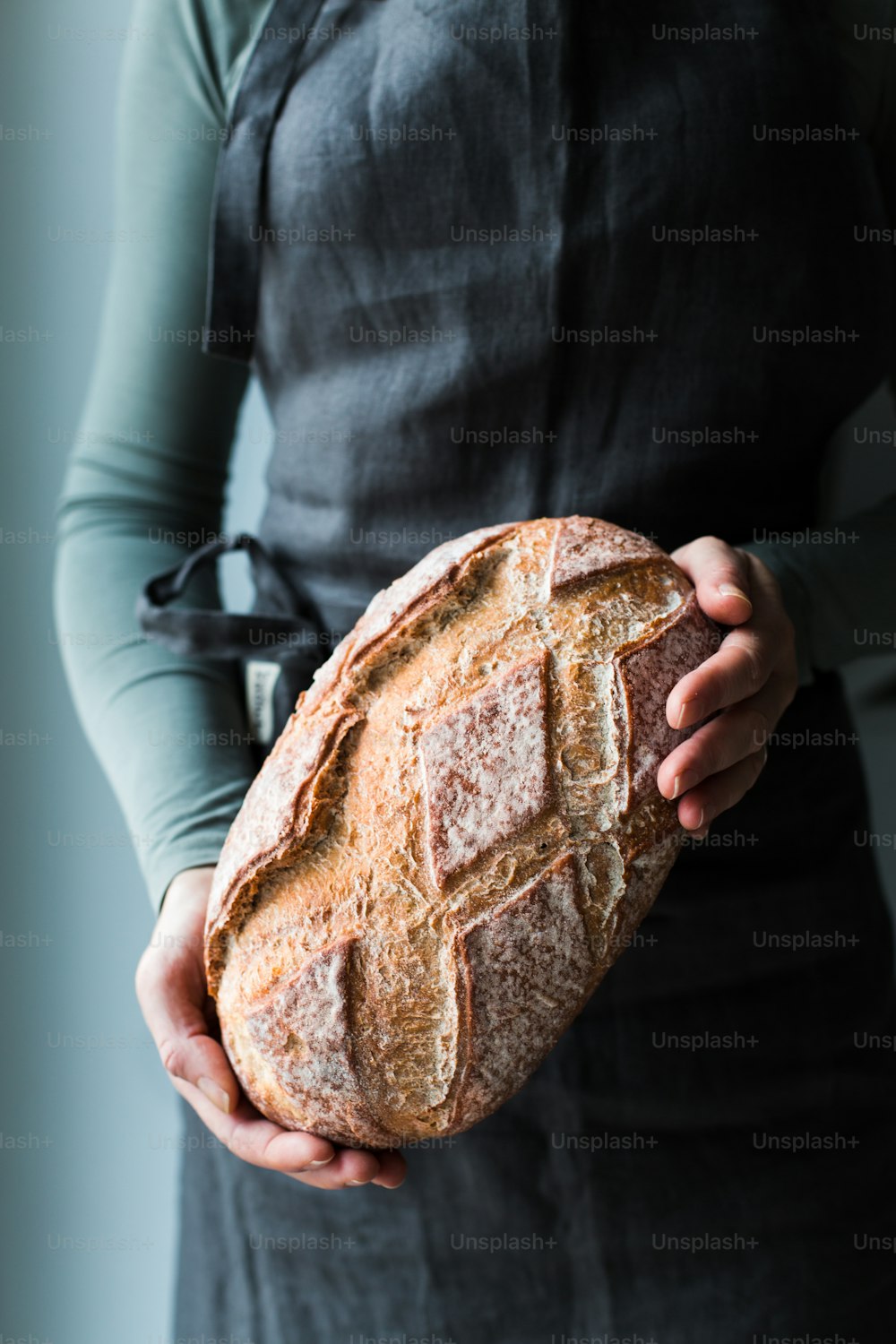 a person holding a loaf of bread in their hands