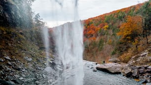 a waterfall with a person standing in the middle of it