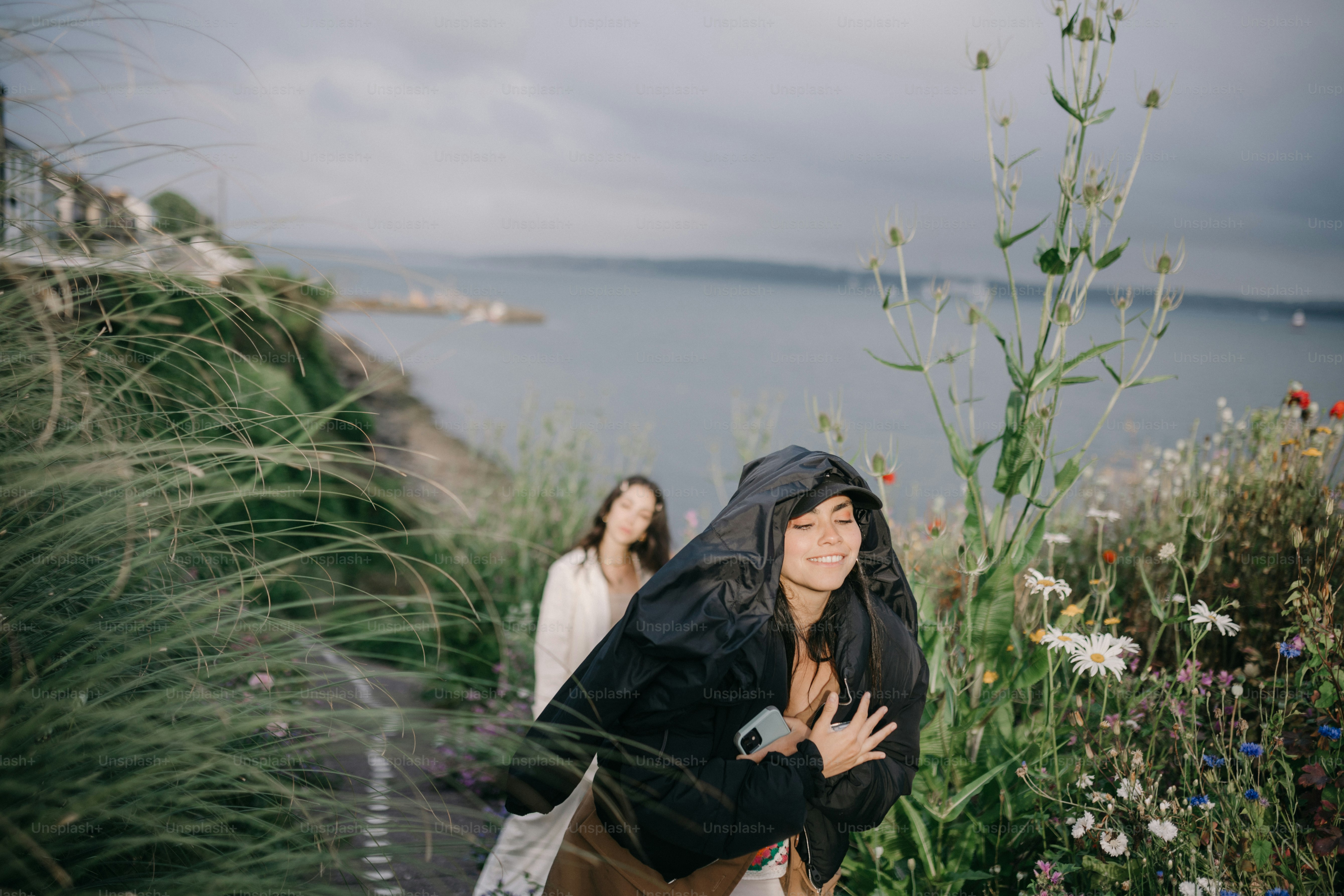 two women are standing in a field of flowers
