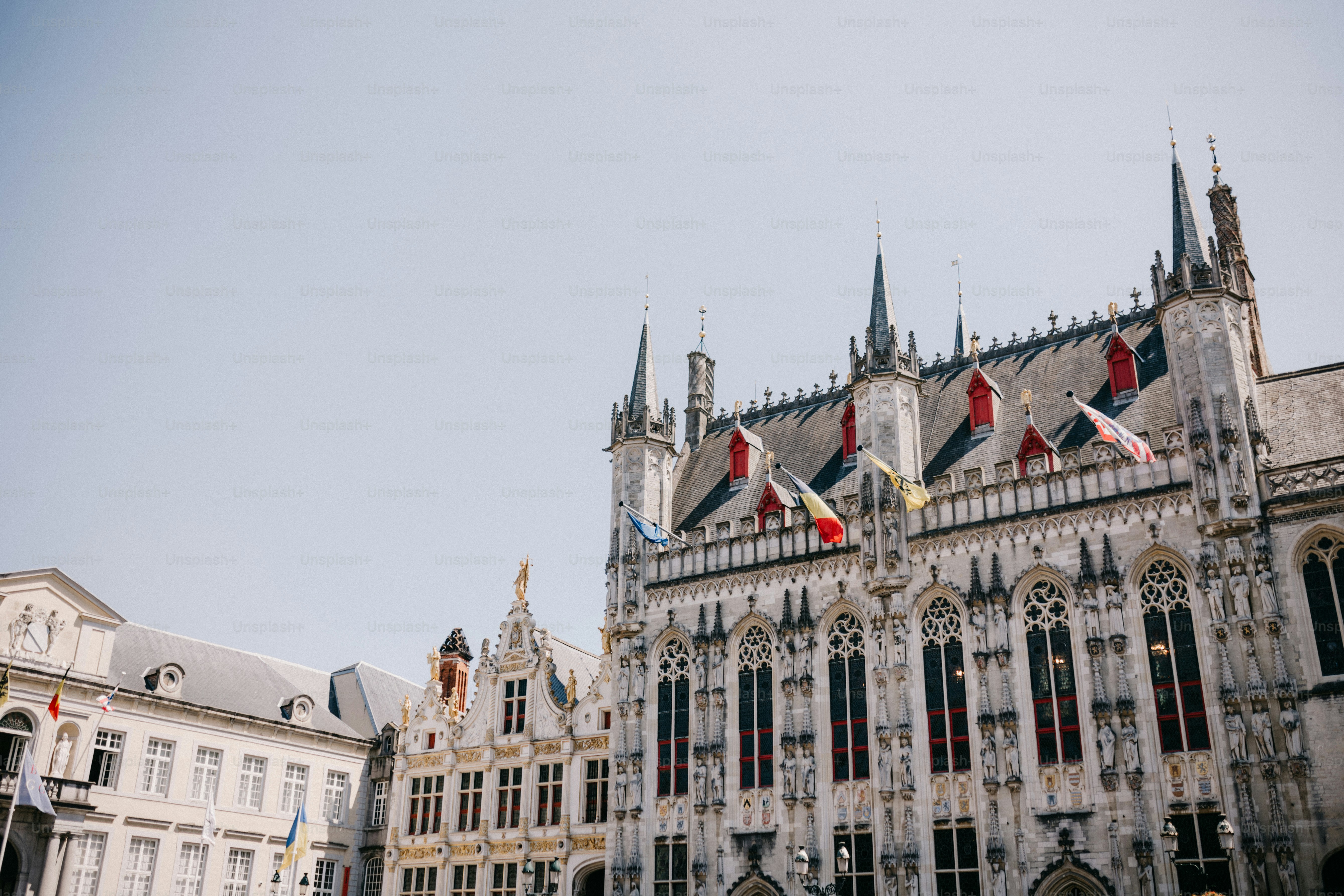 A large building with flags flying in front of it photo – Clock tower ...