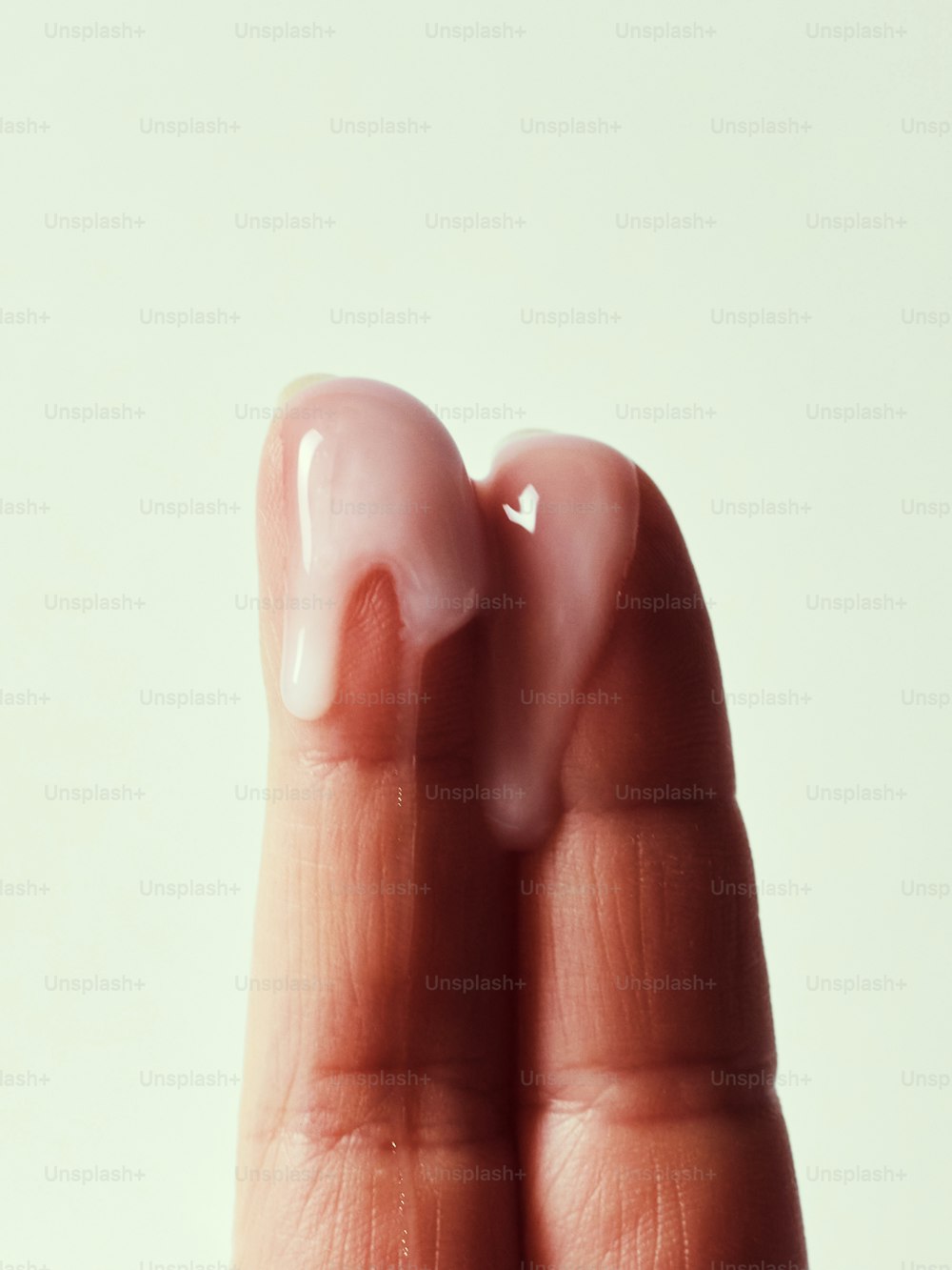 Die Hand einer Person, die einen falschen Zahn in Form eines Daumens hält