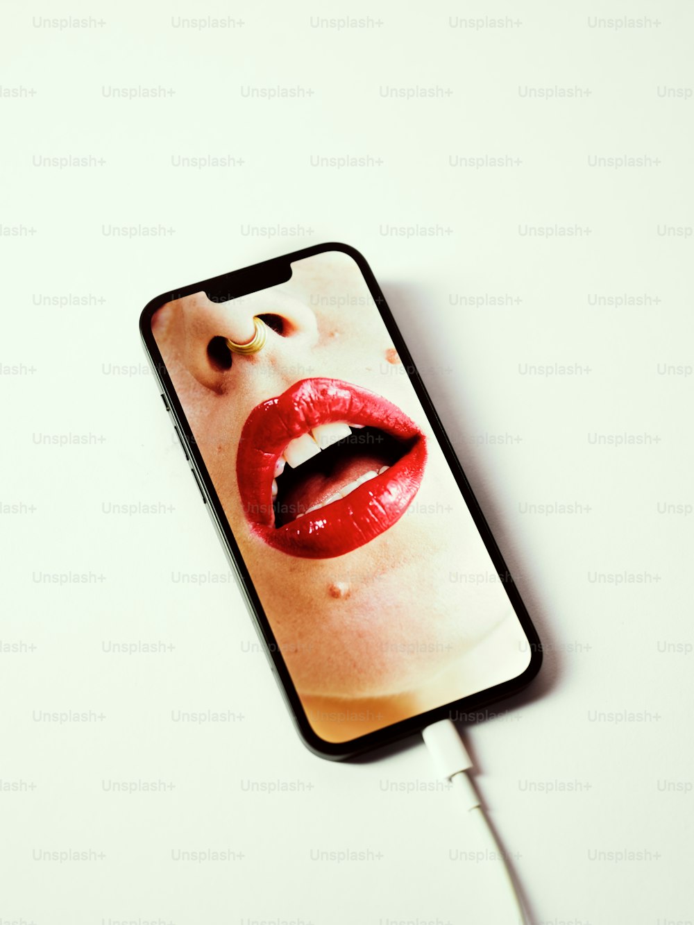 um celular com uma foto da boca de uma mulher nele;