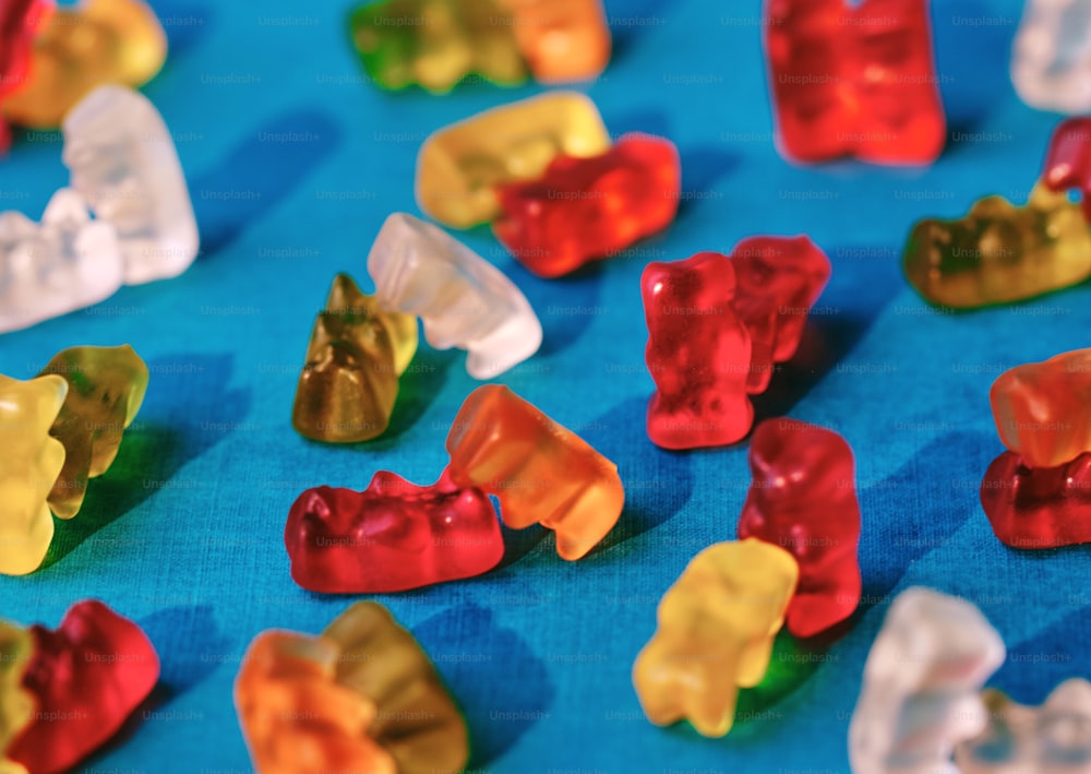 a group of gummy bears sitting on top of a blue table