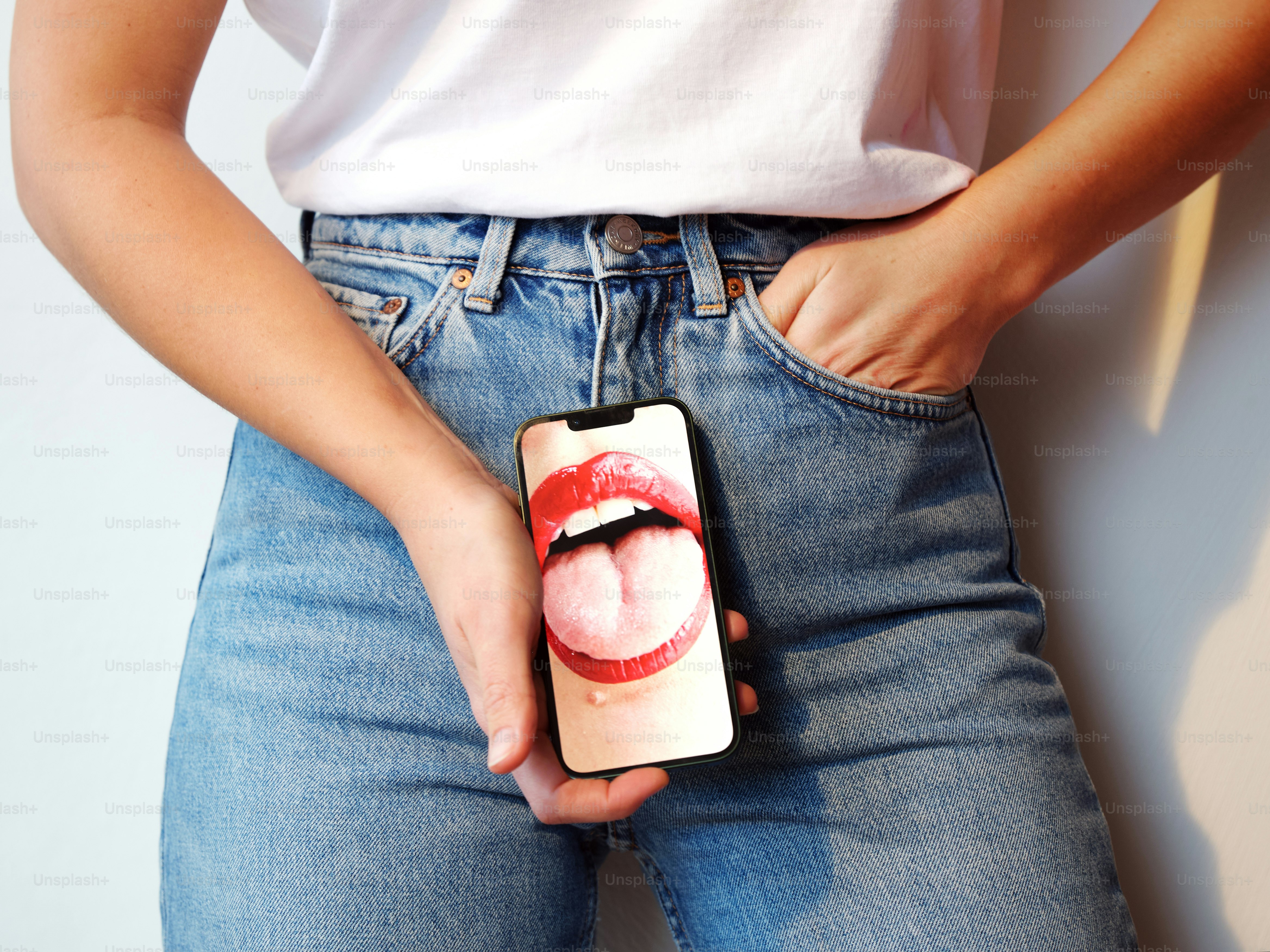 una persona sosteniendo un teléfono celular con una imagen de los labios de una mujer