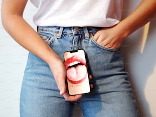 eine Person, die ein Handy mit einem Bild der Lippen einer Frau in der Hand hält