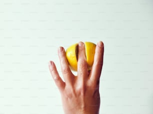 une personne tenant un citron à son visage