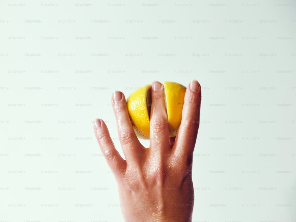 uma pessoa segurando um limão até o rosto