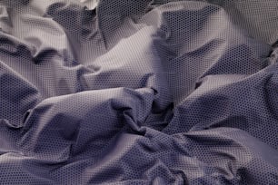 a close up of a bed with a purple comforter