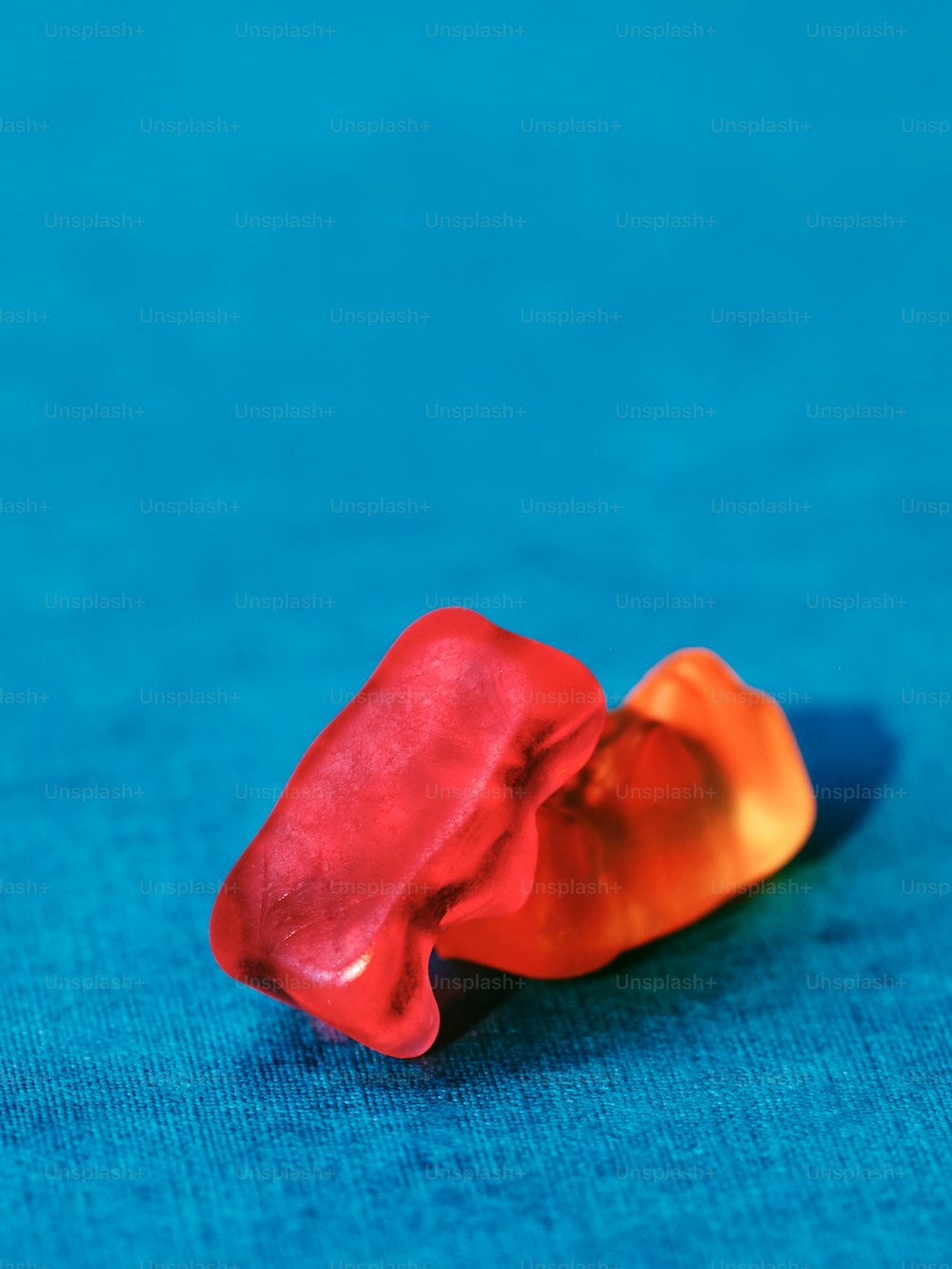 ein rotes und orangefarbenes Objekt, das auf einer blauen Oberfläche sitzt