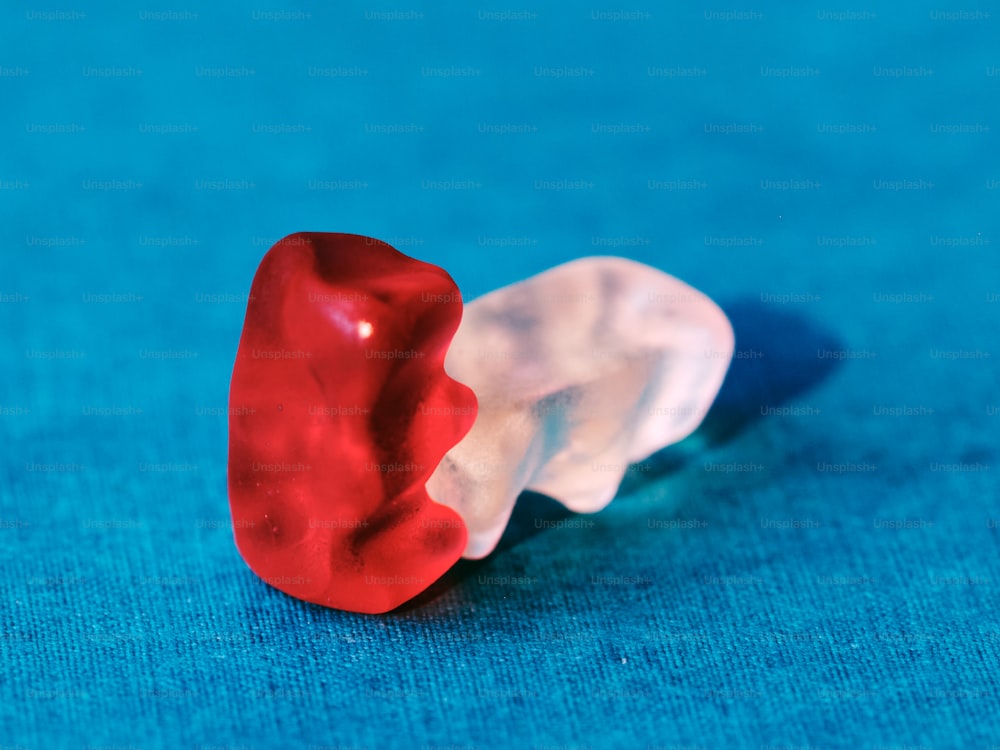 a red and white toothbrush sitting on top of a blue surface