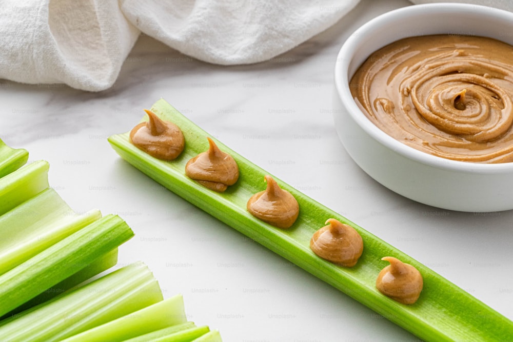 a bowl of peanut butter and celery sticks