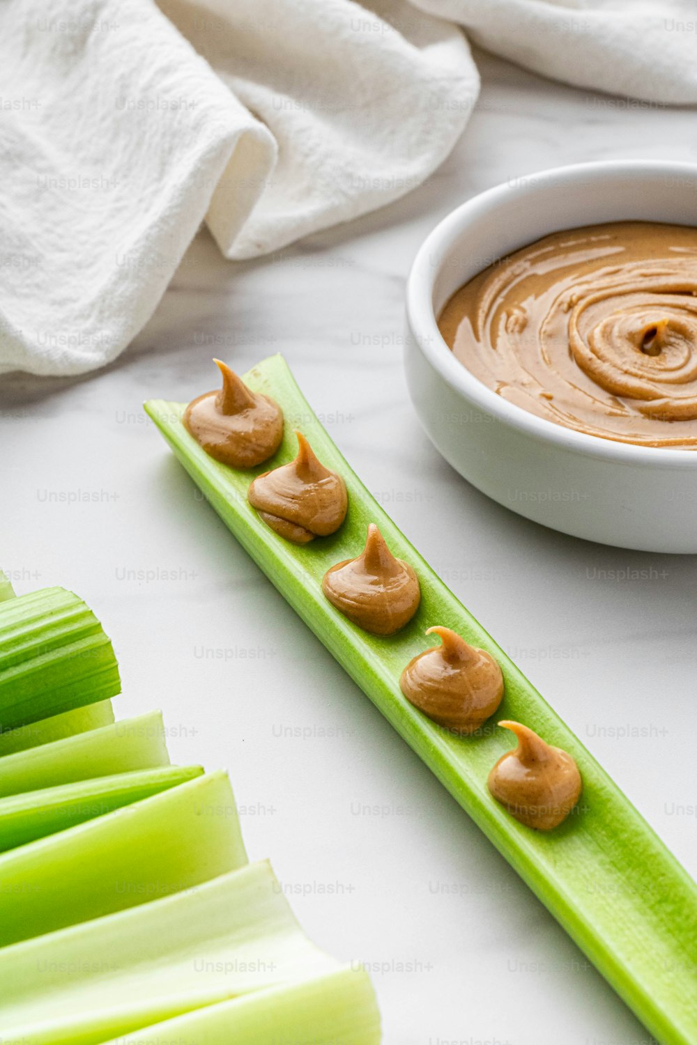 a bowl of peanut butter and celery on a table