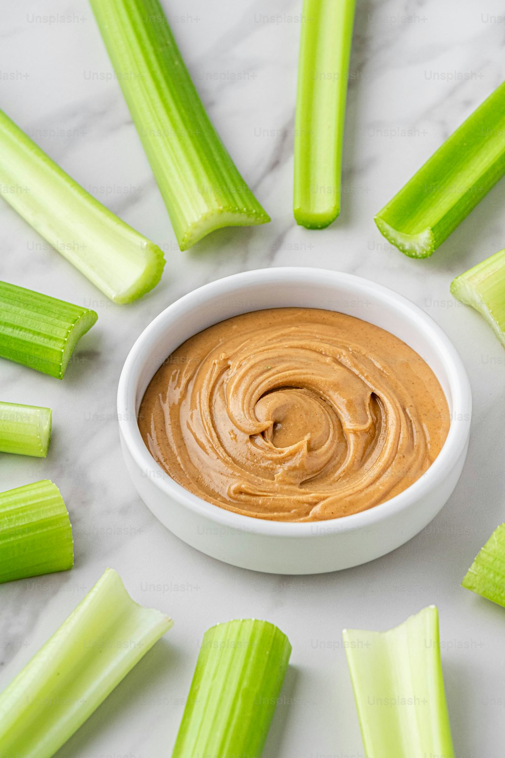 celery sticks and dip in a white bowl