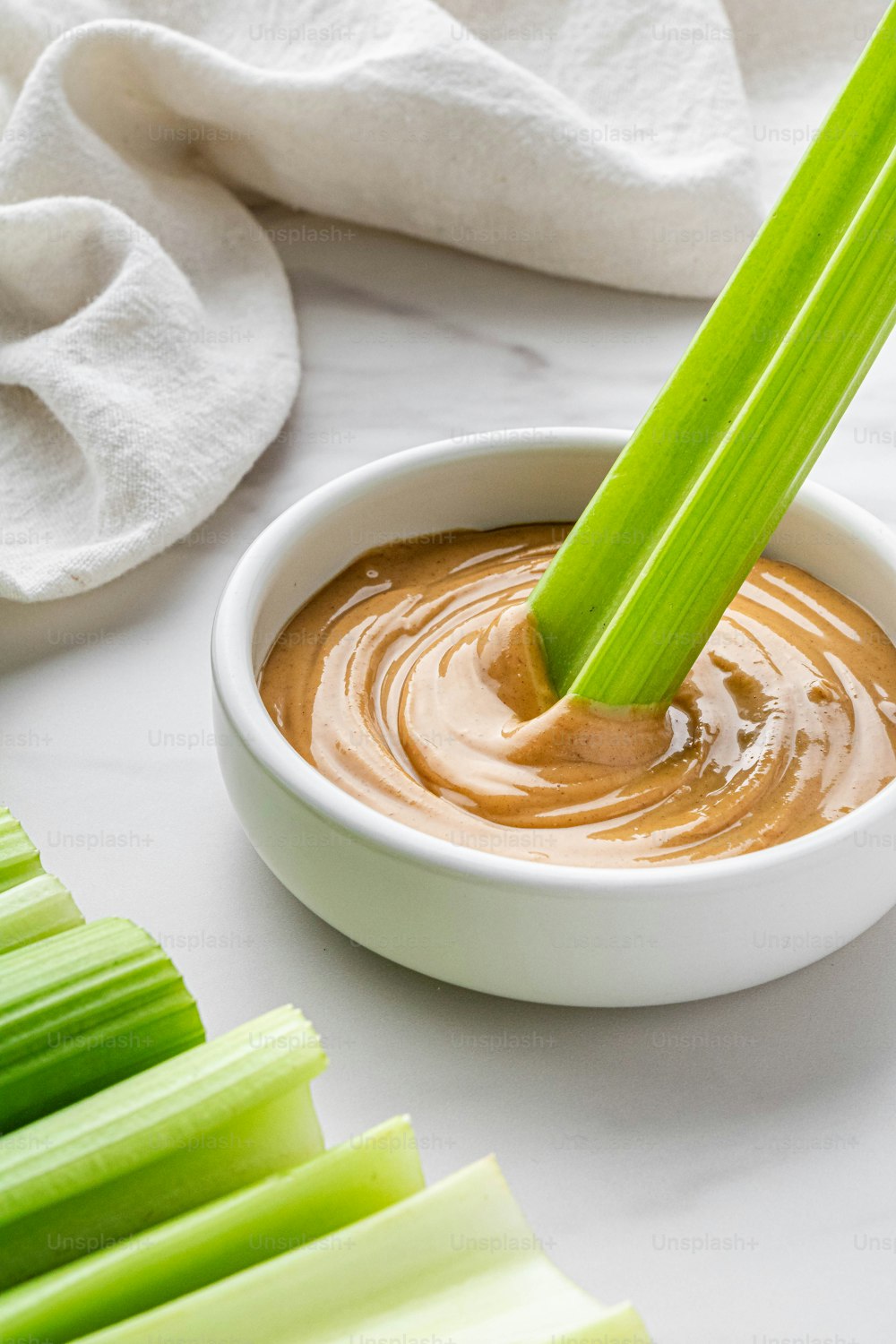 a bowl of peanut butter and celery sticks