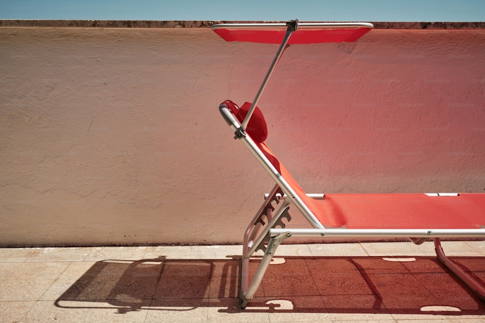 uma cadeira vermelha sentada em cima de um piso de azulejos