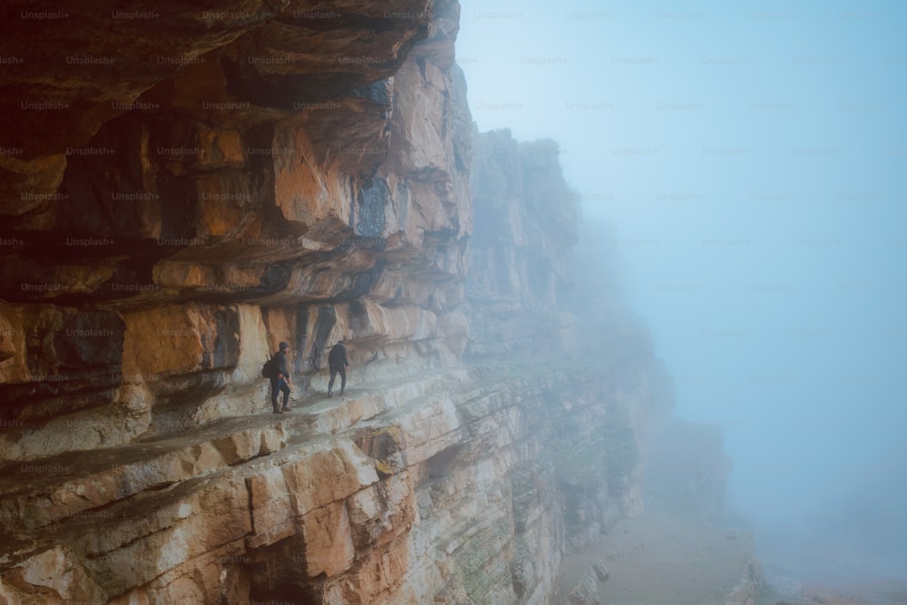 a group of people climbing up the side of a cliff