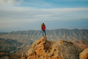 a man standing on top of a large rock